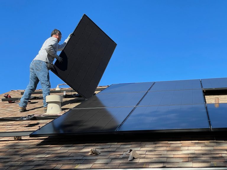 image homme sur un toit pose des panneaux solaire